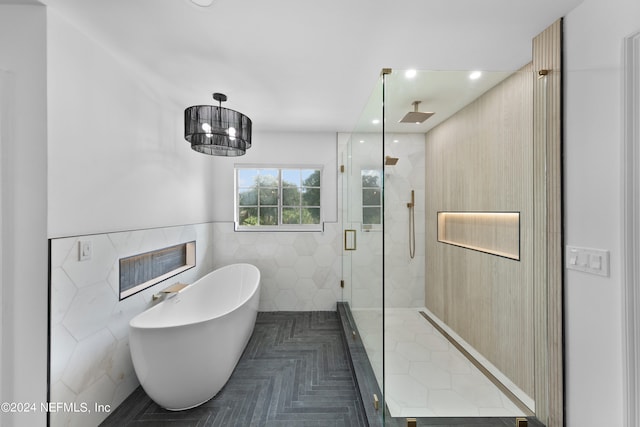 bathroom with parquet floors, independent shower and bath, and tile walls