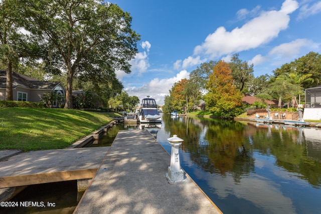 dock area with a water view and a lawn