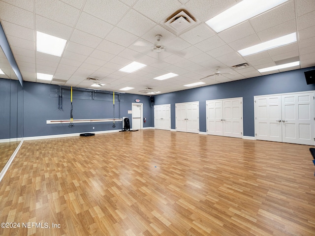 workout area featuring a paneled ceiling and hardwood / wood-style flooring