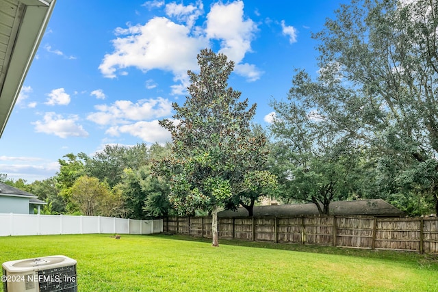 view of yard with central air condition unit and a fenced backyard