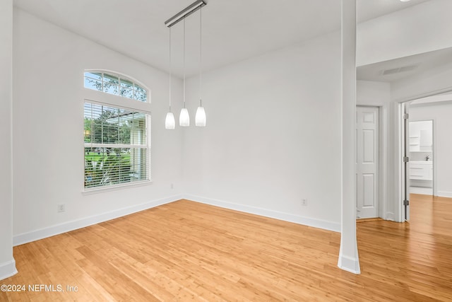 unfurnished dining area with light wood-style floors, baseboards, and visible vents
