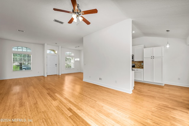 unfurnished living room featuring a wealth of natural light, visible vents, and light wood-style flooring