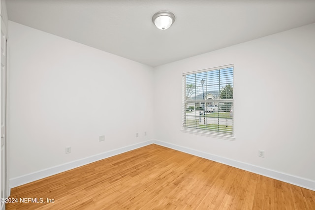empty room with light wood finished floors and baseboards