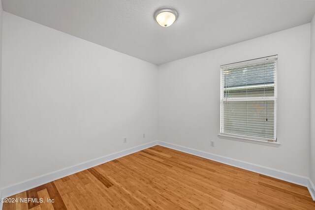 empty room featuring baseboards and light wood-type flooring
