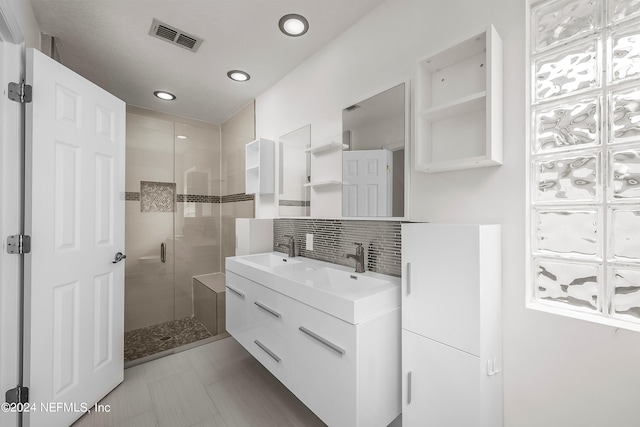 bathroom featuring backsplash, vanity, and an enclosed shower