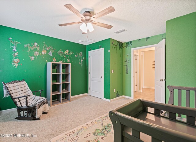 carpeted bedroom featuring a textured ceiling and ceiling fan