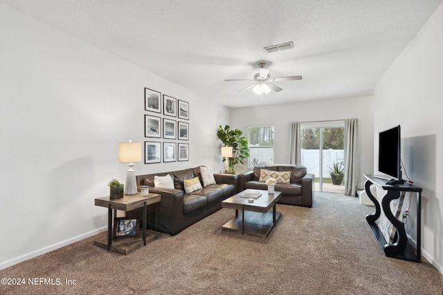 carpeted living room with ceiling fan and a textured ceiling