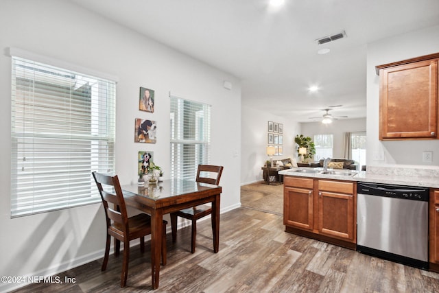 kitchen with stainless steel dishwasher, hardwood / wood-style floors, and a wealth of natural light