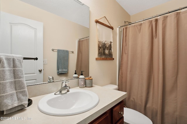 bathroom with curtained shower, vanity, and toilet