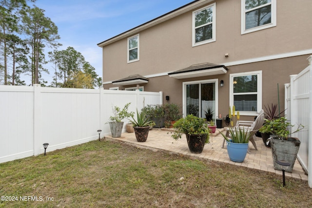 rear view of property with a patio area and a yard