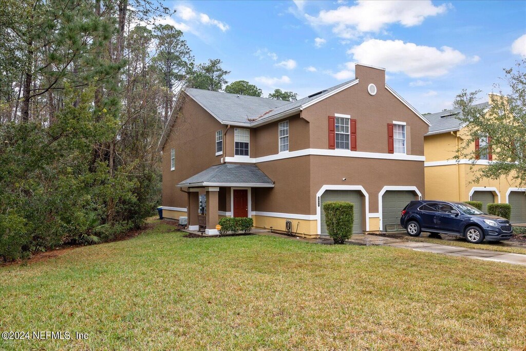 view of front of property featuring a front yard and a garage