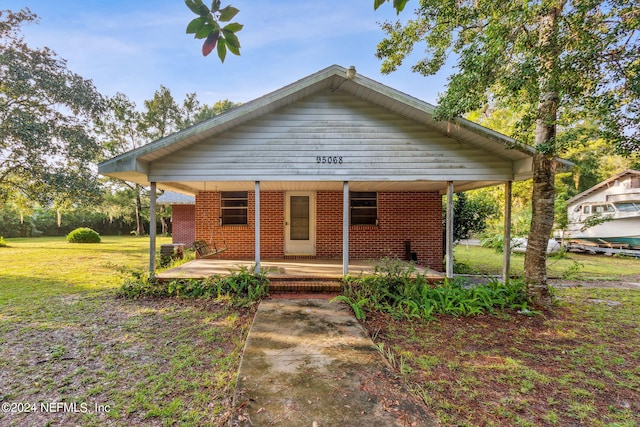 bungalow with a front lawn and covered porch