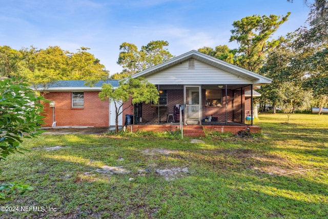 back of property featuring a lawn and a porch