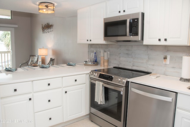 kitchen featuring white cabinetry, appliances with stainless steel finishes, tasteful backsplash, and light tile patterned floors