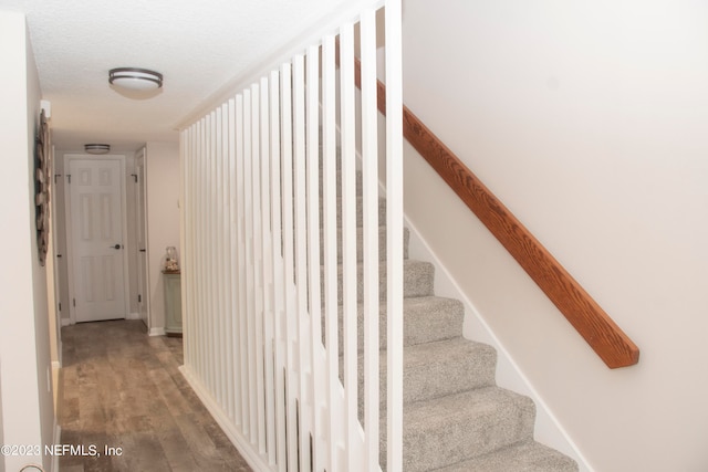 staircase featuring hardwood / wood-style flooring and a textured ceiling