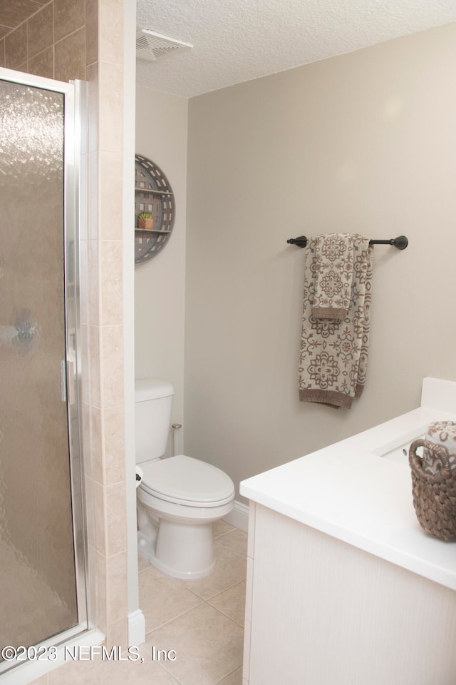 bathroom with vanity, tile patterned flooring, toilet, and walk in shower