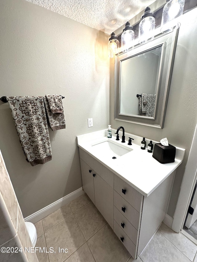 bathroom featuring tile patterned floors, vanity, and a textured ceiling