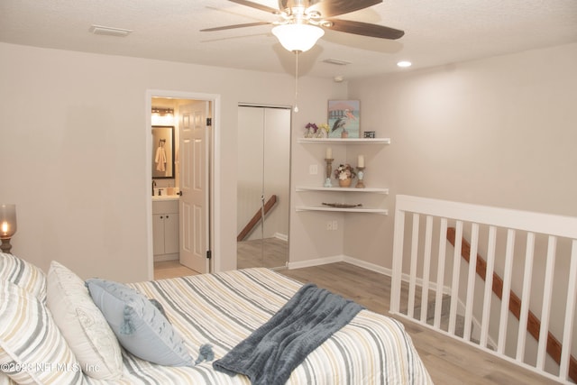 bedroom with connected bathroom, ceiling fan, light hardwood / wood-style floors, a textured ceiling, and a closet