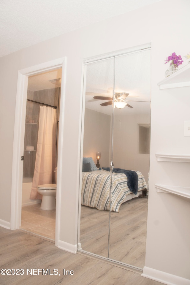 bedroom with hardwood / wood-style flooring, ensuite bath, and a closet