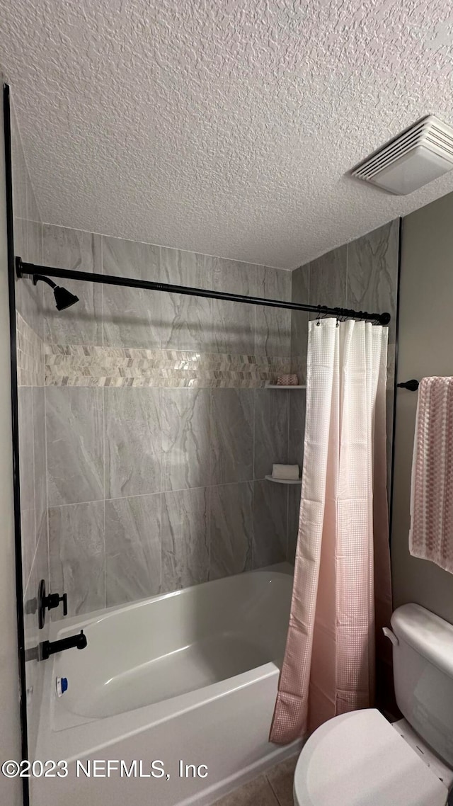 bathroom featuring a textured ceiling, toilet, and shower / bath combo