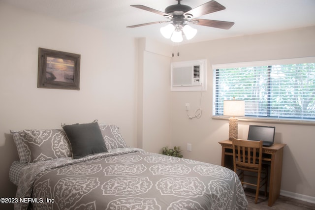 bedroom with a wall unit AC and ceiling fan