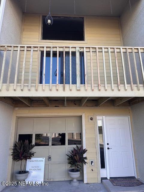 doorway to property featuring a garage and a balcony