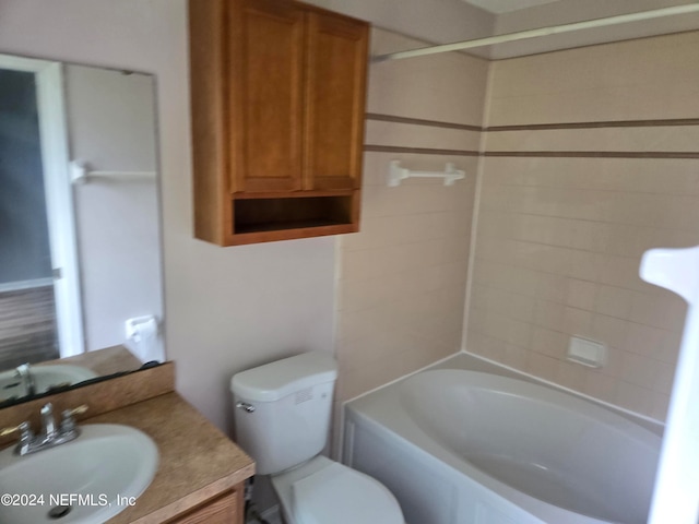 full bathroom with tiled shower / bath, vanity, and toilet