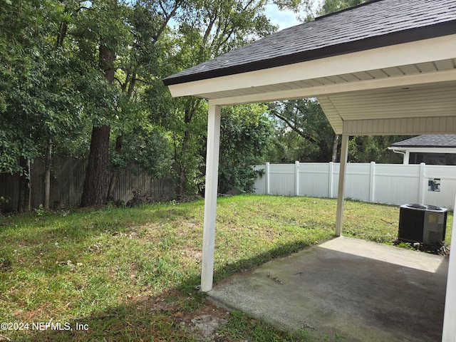 view of yard with central AC unit and a patio area