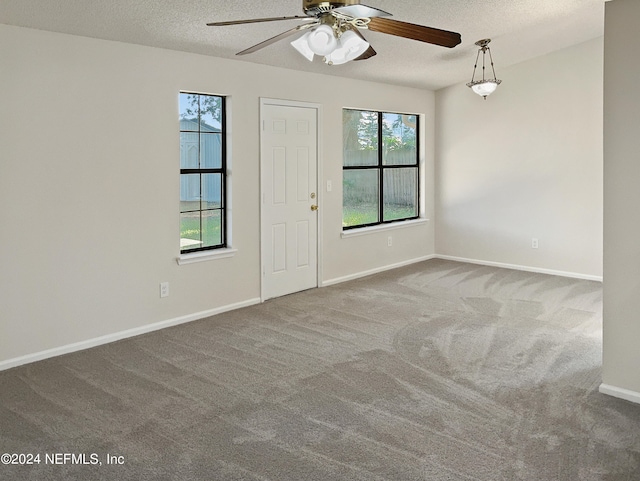 carpeted foyer featuring a textured ceiling and ceiling fan