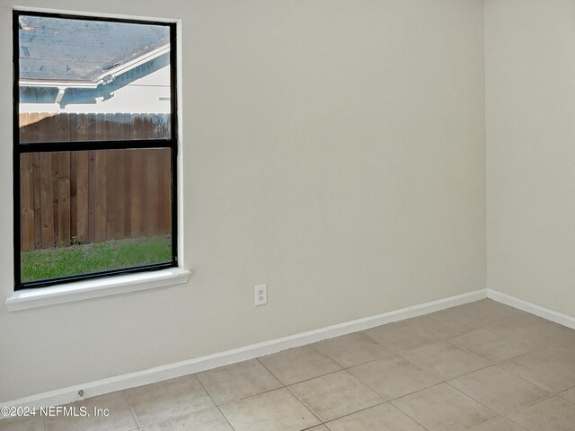 tiled spare room featuring plenty of natural light