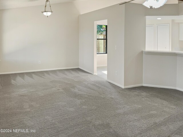 unfurnished living room with lofted ceiling and light colored carpet