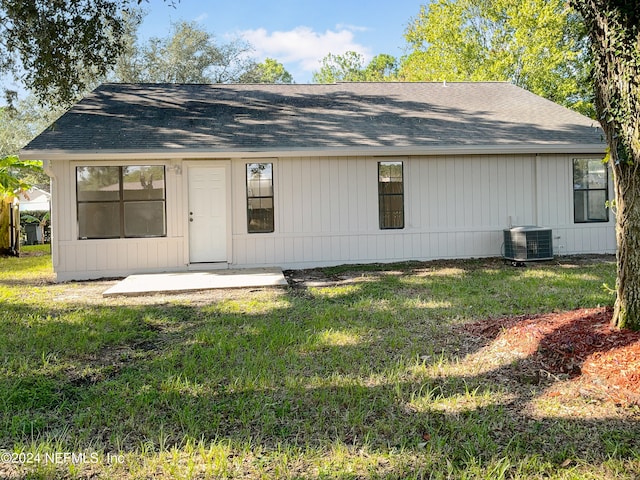 back of property with a lawn and central air condition unit