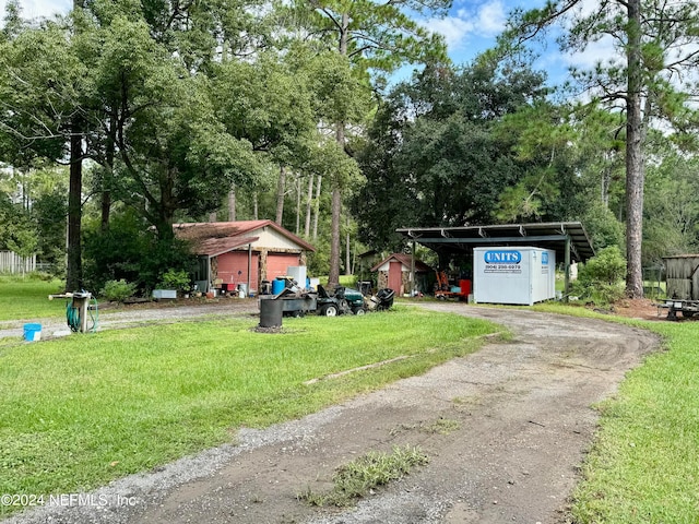 exterior space with a storage shed, a carport, and a front lawn