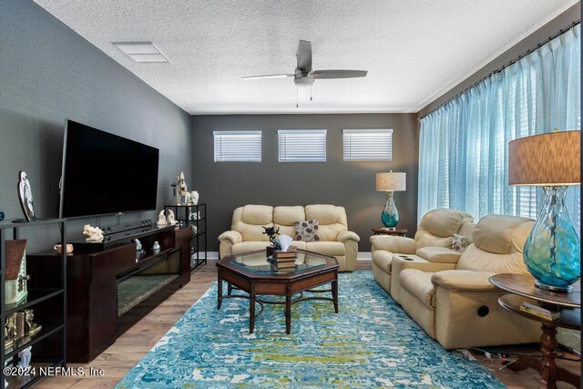 living room featuring a textured ceiling, ceiling fan, and hardwood / wood-style flooring