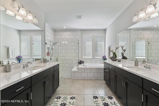 bathroom with tile patterned flooring, a textured ceiling, independent shower and bath, and vanity