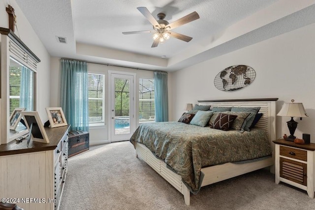 bedroom with carpet, a tray ceiling, ceiling fan, and access to exterior