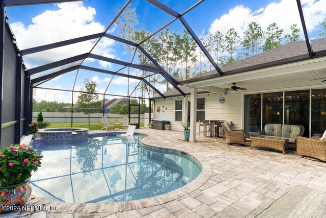 view of swimming pool with glass enclosure, a patio, an in ground hot tub, an outdoor living space, and ceiling fan