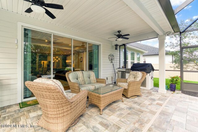 view of patio / terrace featuring glass enclosure, area for grilling, and ceiling fan