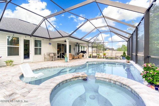 view of pool with an in ground hot tub, a lanai, ceiling fan, and a patio area