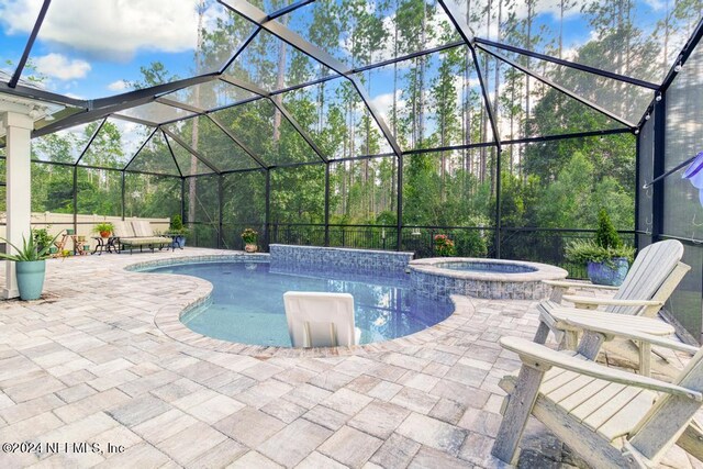 view of swimming pool with a lanai, a patio, and an in ground hot tub