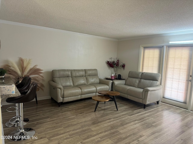 living room with a textured ceiling, crown molding, and hardwood / wood-style flooring