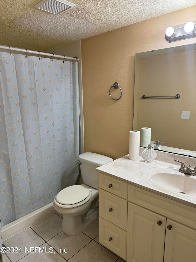 bathroom featuring tile patterned floors, a textured ceiling, vanity, and toilet