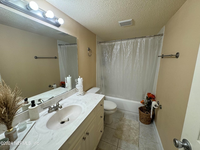 full bathroom with tile patterned flooring, a textured ceiling, shower / tub combo with curtain, vanity, and toilet