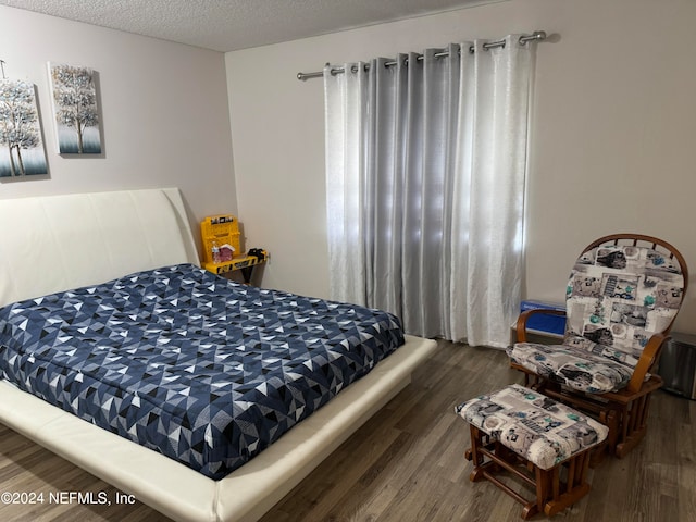 bedroom featuring wood-type flooring and a textured ceiling