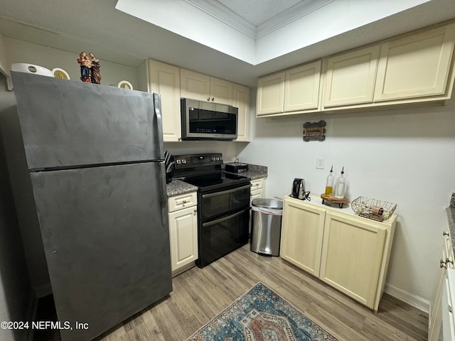 kitchen featuring appliances with stainless steel finishes, cream cabinetry, light hardwood / wood-style floors, and ornamental molding