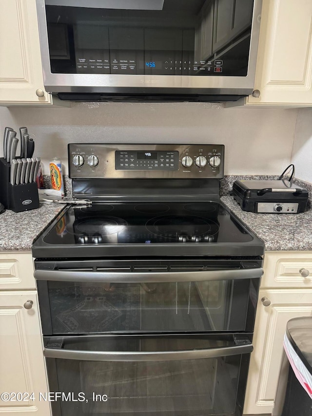 kitchen with light stone countertops and stainless steel appliances