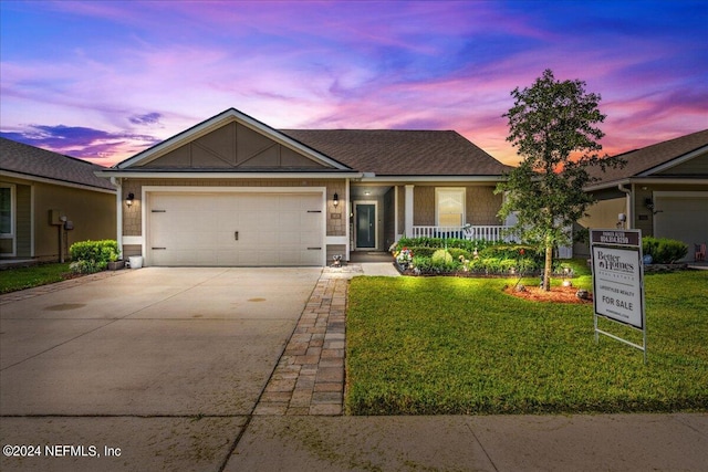 ranch-style home featuring a lawn and a garage