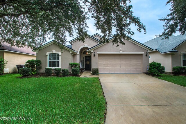 ranch-style home with a garage and a front lawn