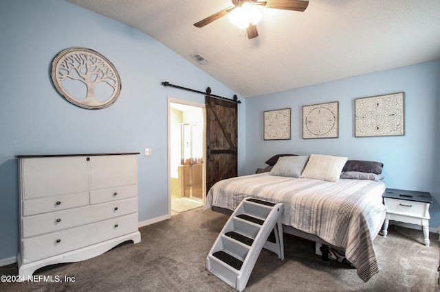 carpeted bedroom featuring a textured ceiling, lofted ceiling, a barn door, ensuite bathroom, and ceiling fan