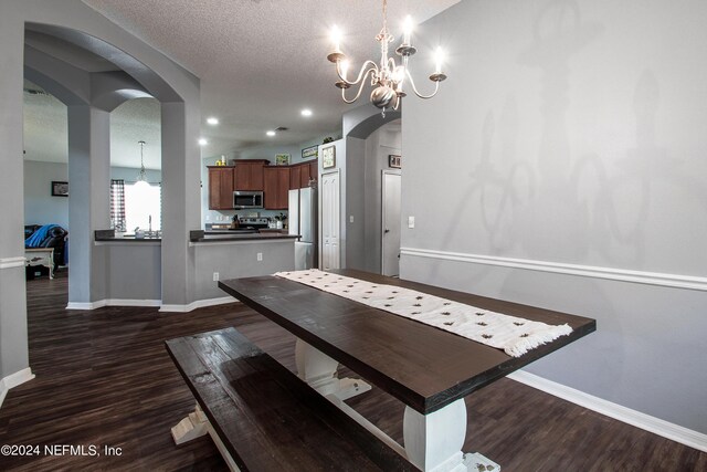 unfurnished dining area with an inviting chandelier, dark hardwood / wood-style flooring, and a textured ceiling